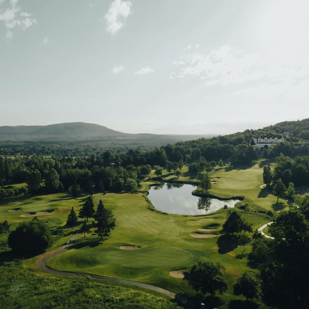 Plan aérien du Golf Château-Bromont, avec des allées verdoyantes et un plan d'eau.