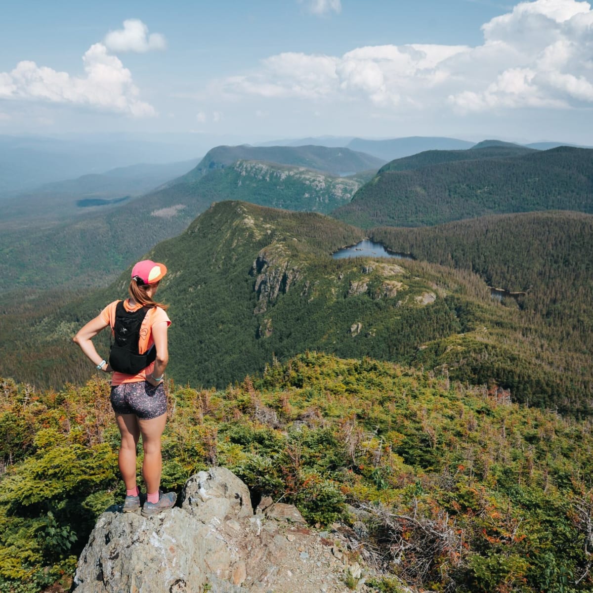 Femme au sommet d'une montagne au Parc national de la Gaspésie.