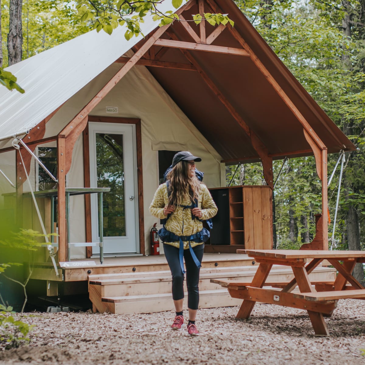 Femme devant une tente de prêt-à-camper.