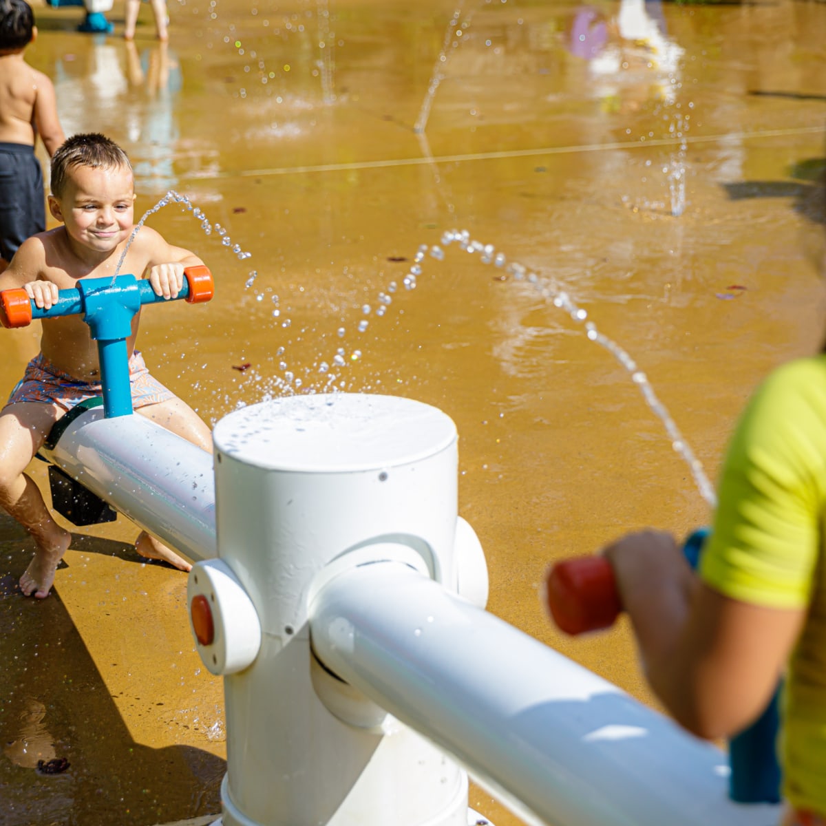 Bambin et sa mère dans les jeux d'eau