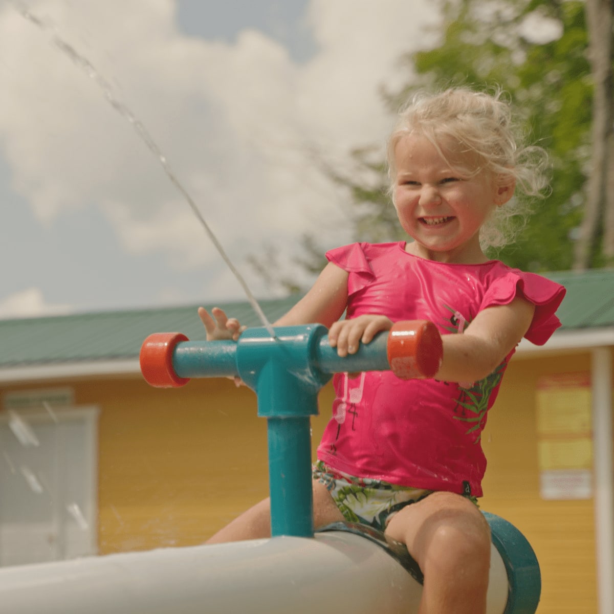 Enfant avec un jeu d'eau à Au Pays des Merveilles.