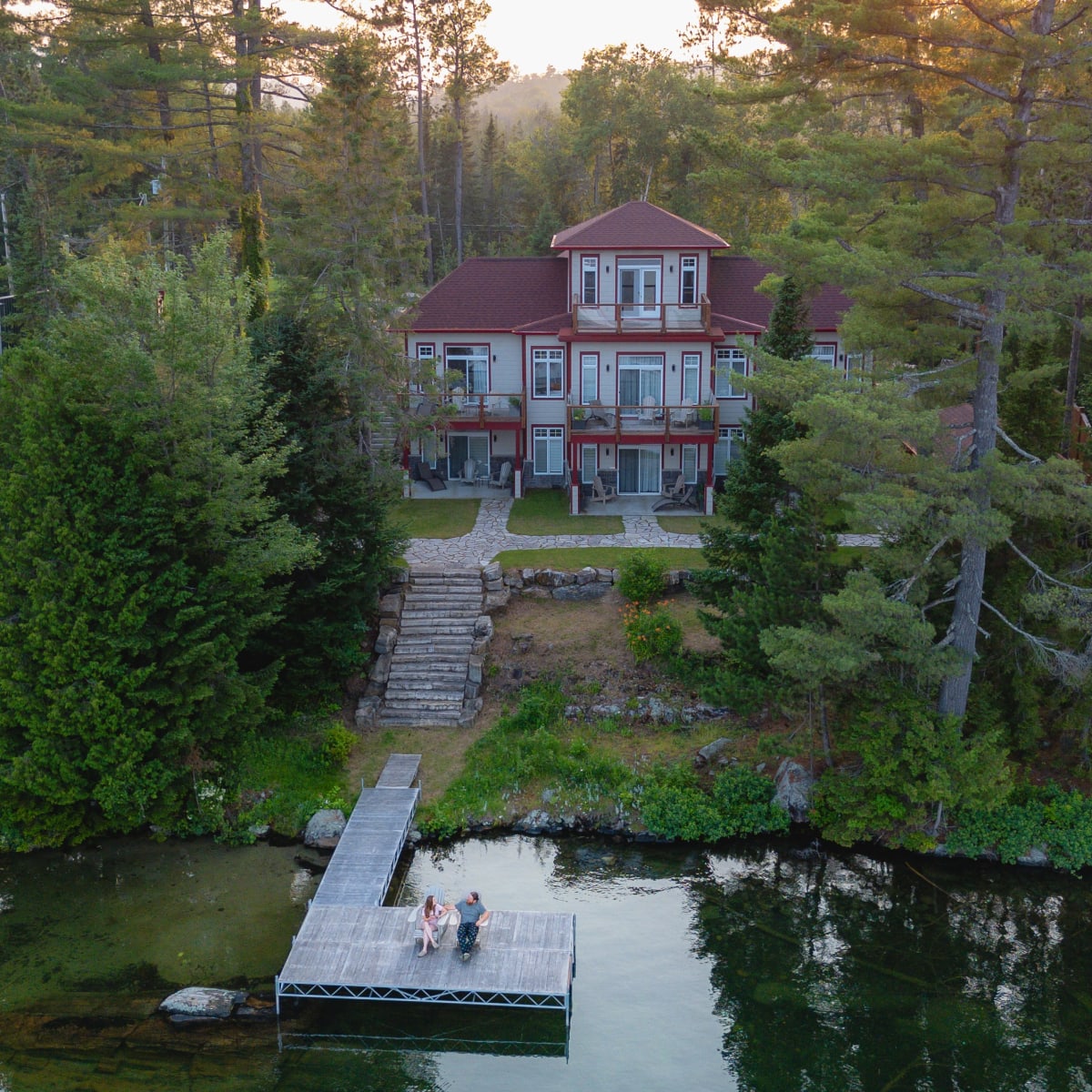 Vue aérienne de l'auberge et du lac en soirée l'été.