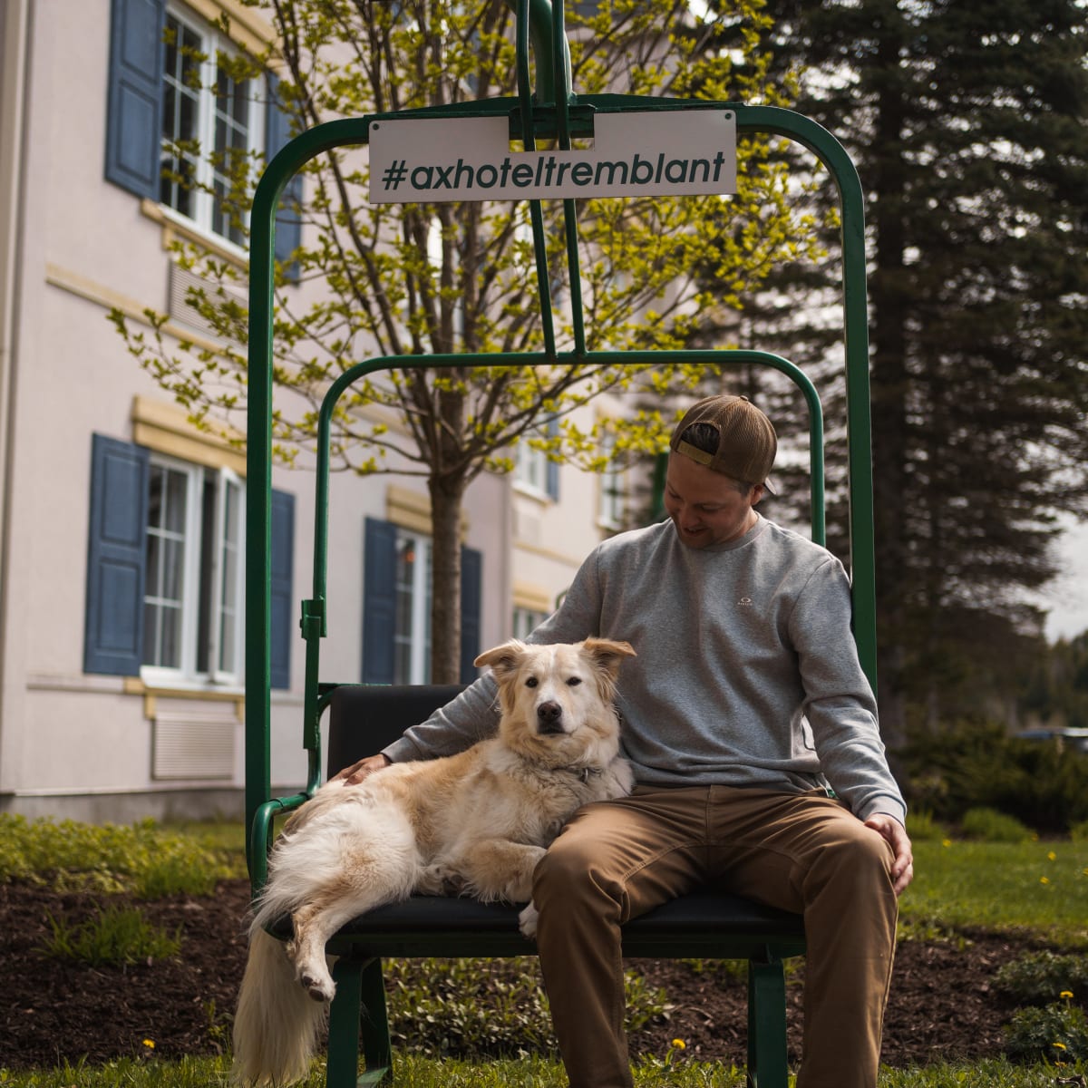 Homme et chien à l'extérieur de l'Ax Hôtel Mont-Tremblant.