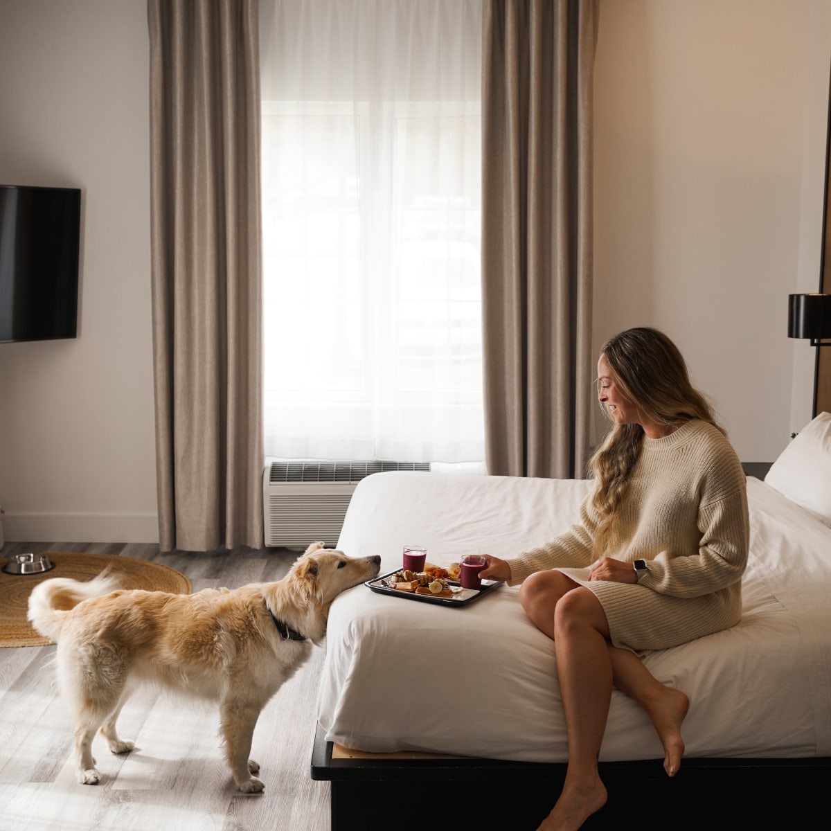 Femme et chien dans la chambre d'hôtel au Ax Hôtel Mont-Tremblant.