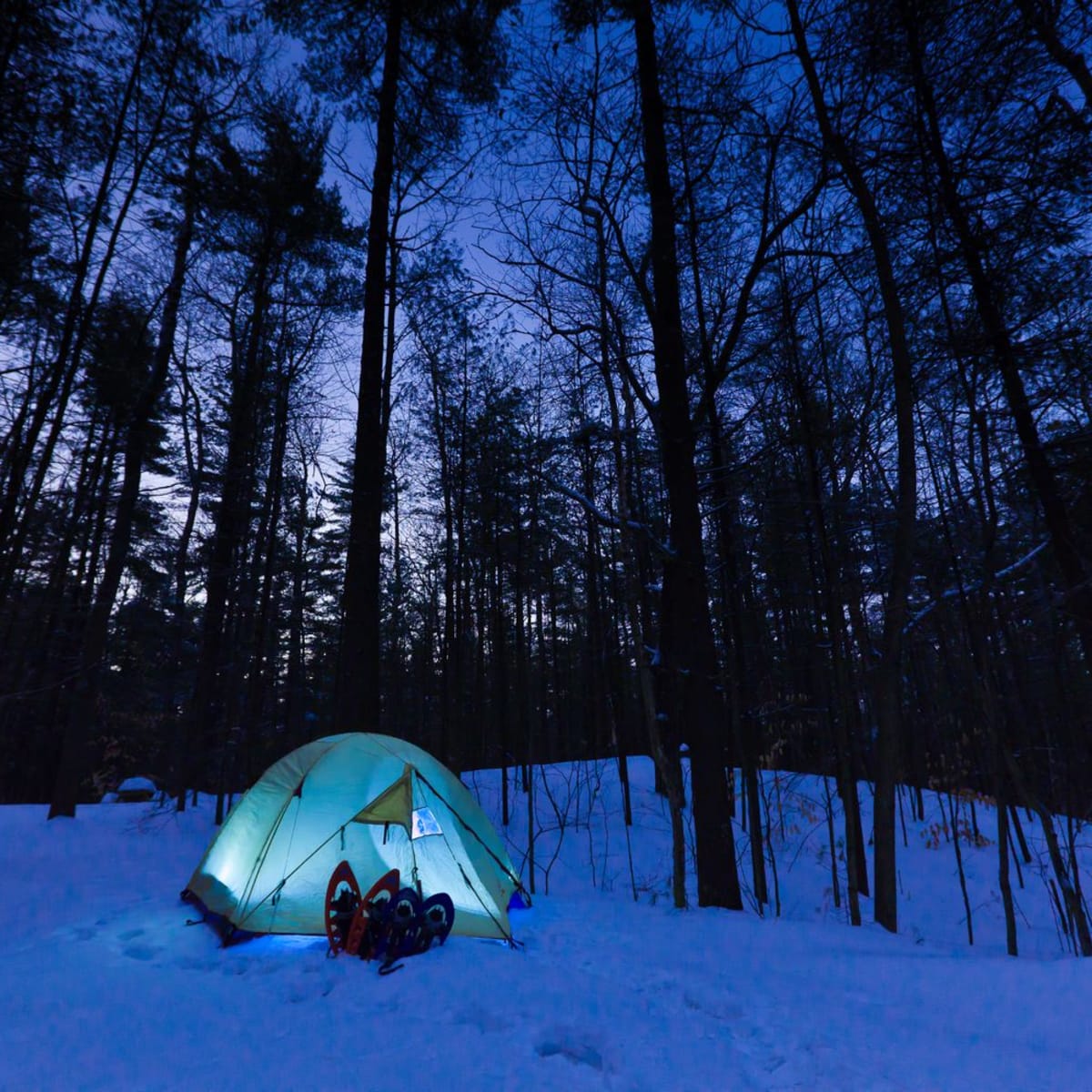 Une tente illuminée en hiver au Camping du parc national d'Oka.