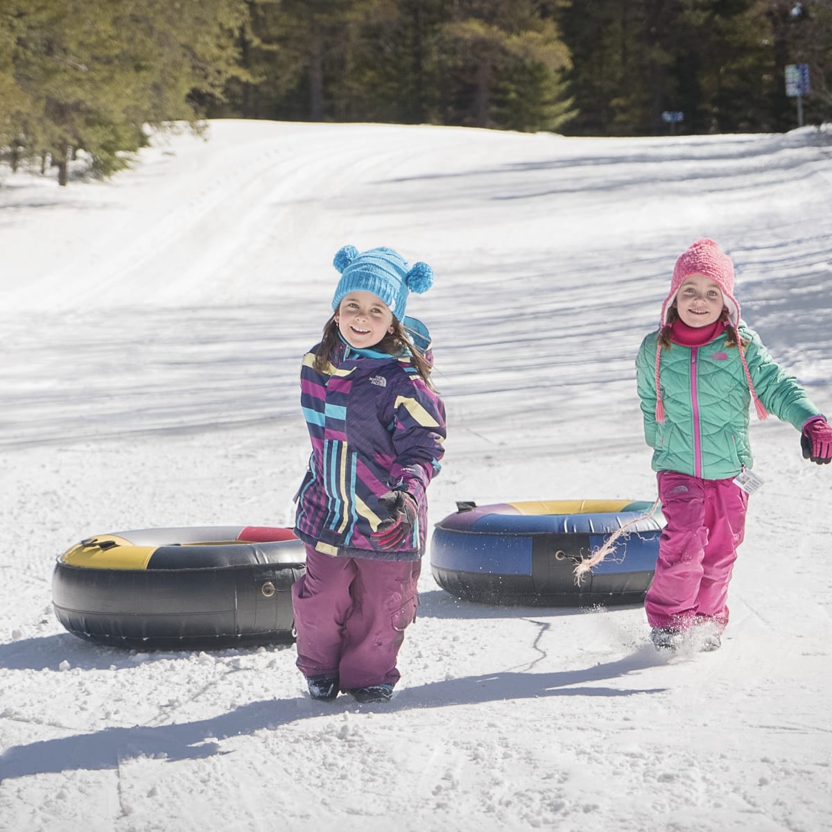 2 fillettes en glissade sur tube aux Sources Joyeuses.