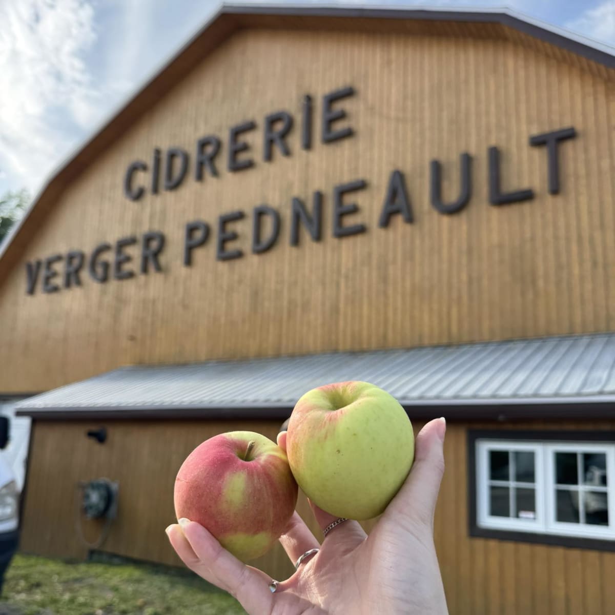 Holding apples in front of the cider house. 
