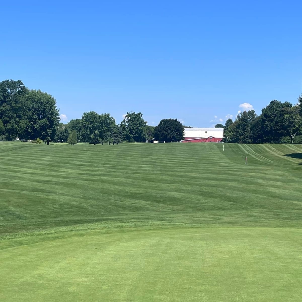Terrain gazonné sous un ciel bleu sans nuage au Club de golf Saint-Anicet.