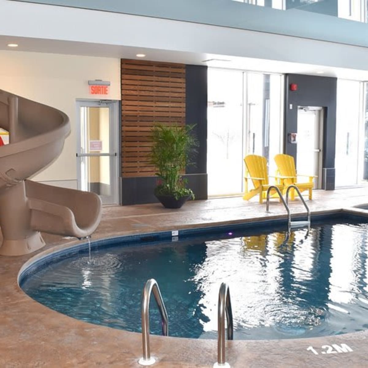 Indoor pool with a slide at the Comfort Inn & Suites Saint-Jérôme