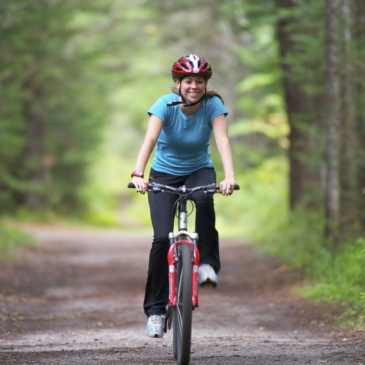 Femme à vélo sur une piste en forêt - Parc de la Mauricie
