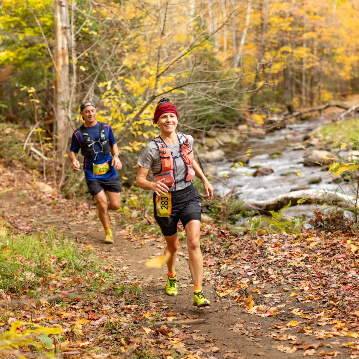 Défi des Couleurs Simard - Deux individus en train de courir dans une forêt automnale