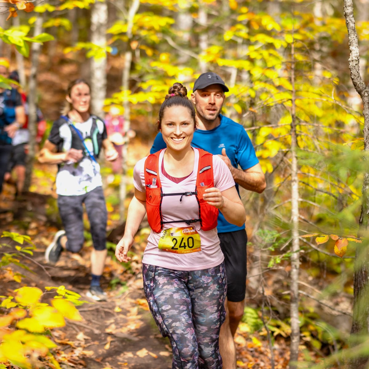 Défi des Couleurs Simard - Quatre individus en train de courir dans une forêt automnale