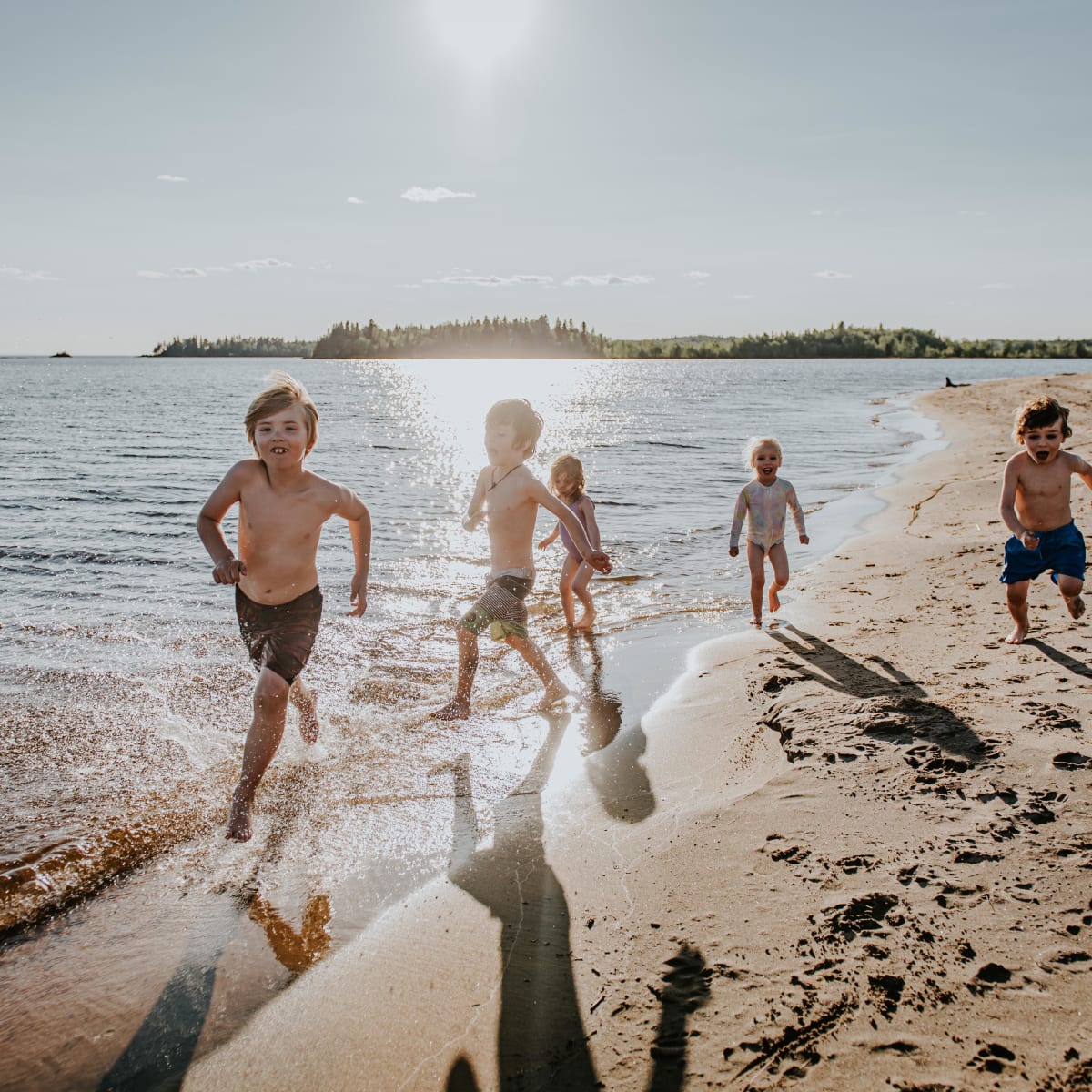 Destination Lac-Saint-Jean des enfants qui courent sur la plage