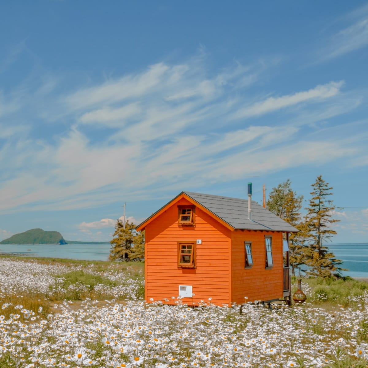 Tiny house orange au bord du fleuve au printemps. 