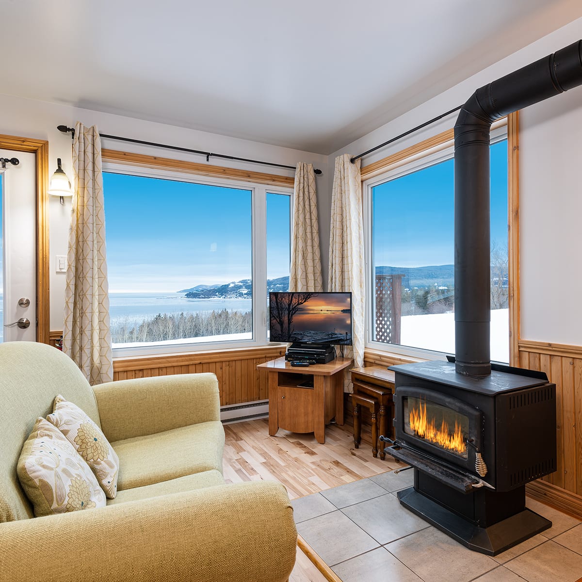 Une pièce avec foyer d'un des chalets du Domaine Frais Air.