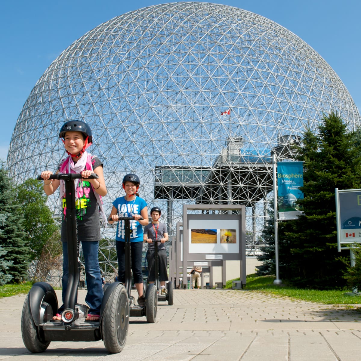Jeune fille et ses parents en Segway devant la Biosphère