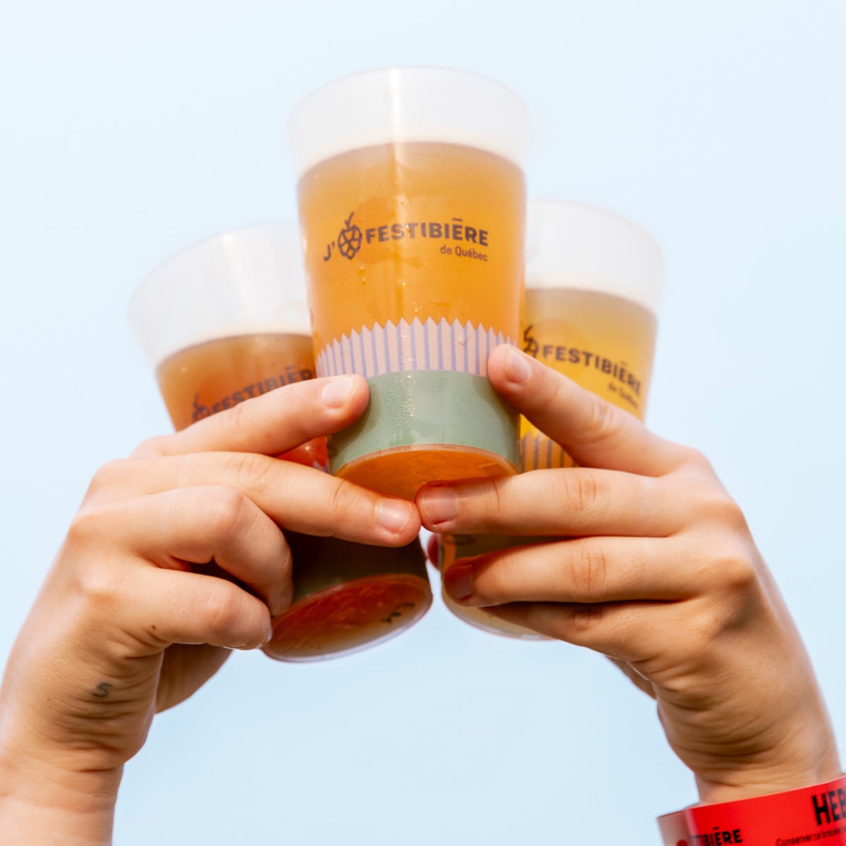 Le Festibière de Québec - Des mains tiennent trois verres remplis d'un liquide