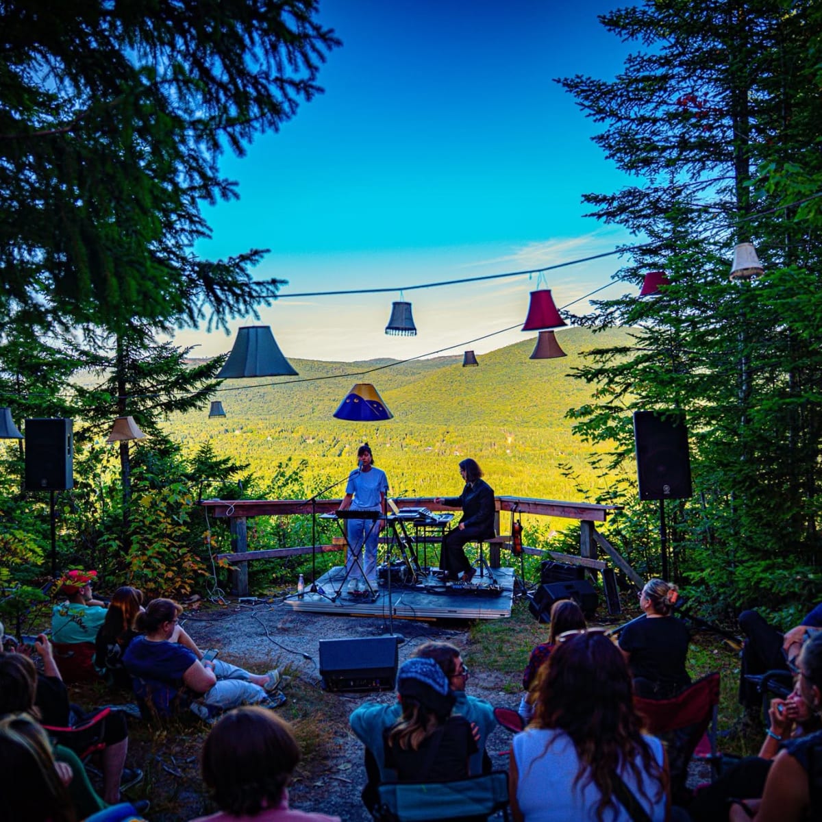 Concert au belvédère : public assis, abat-jours et vue sur la vallée
