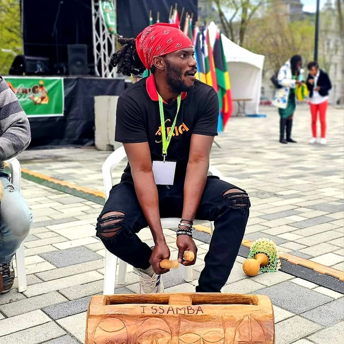 AfriCa Fest - A man is seated and playing an instrument.