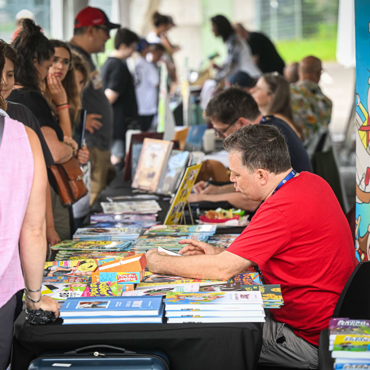 Prévost Comic Arts Festival - Cartoonists sitting at tables meet people