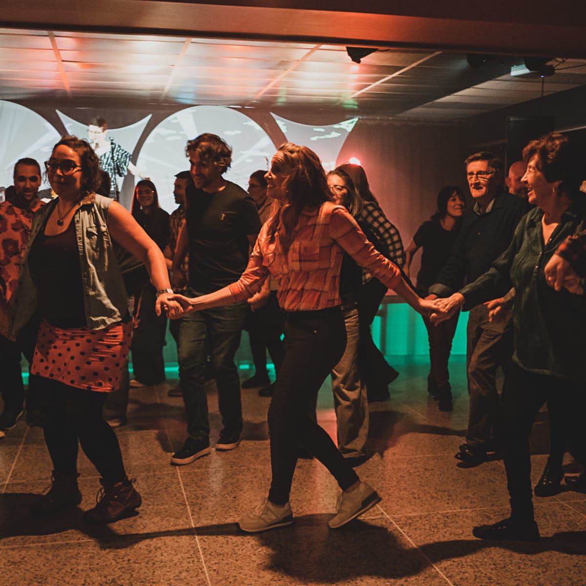 Val-d'Or Traditionnal Music Festival - People dance in a line, holding hands.