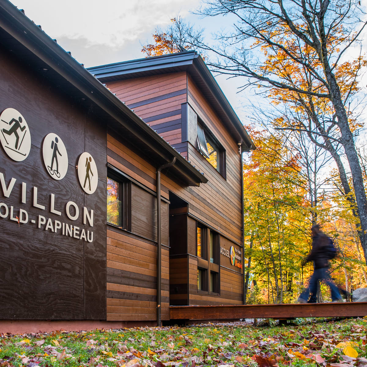 Un adulte marche vers un Pavillon du Parc régional Montagne du Diable, en automne.