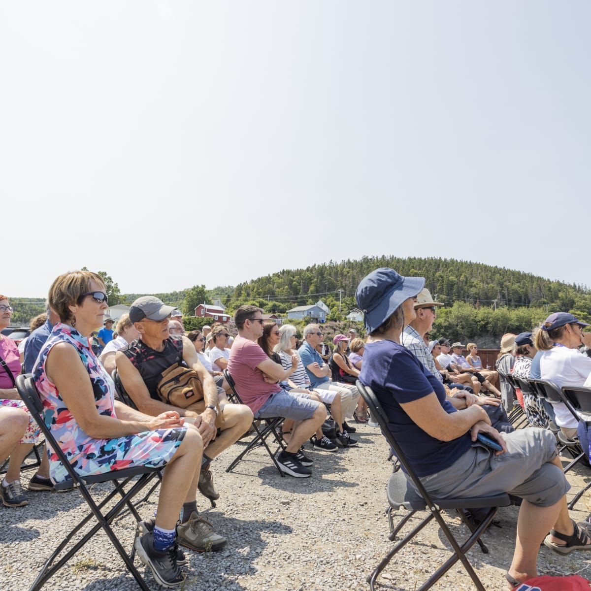Seated crowd at a show next to the sea at Festival en chanson de Petite-Vallée.