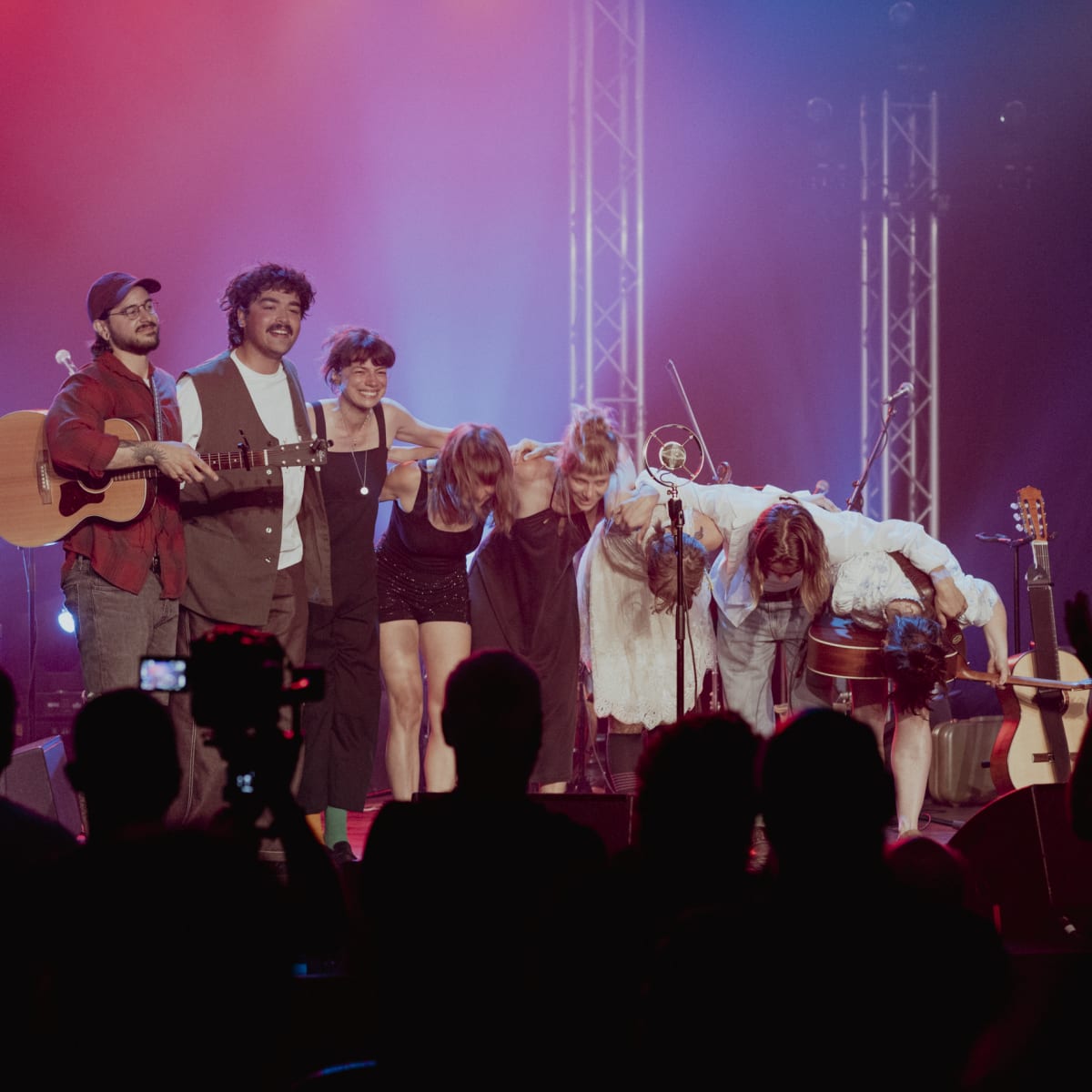 Group of musicians on stage after a performance.