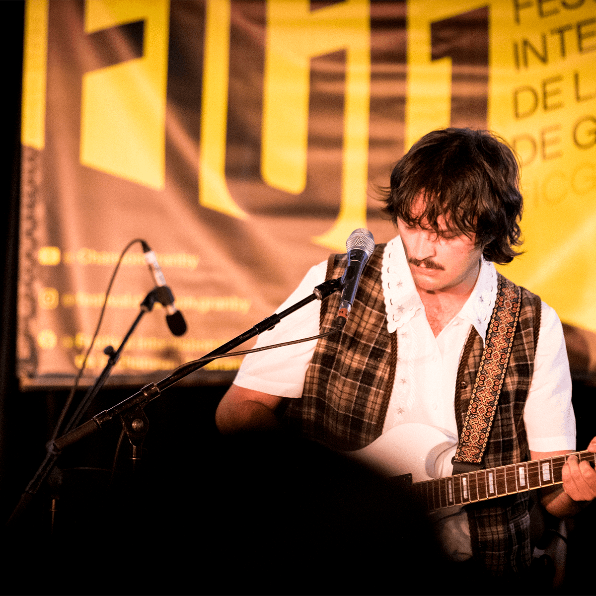 Un artiste joue de la guitare au Festival international de la chanson de Granby.