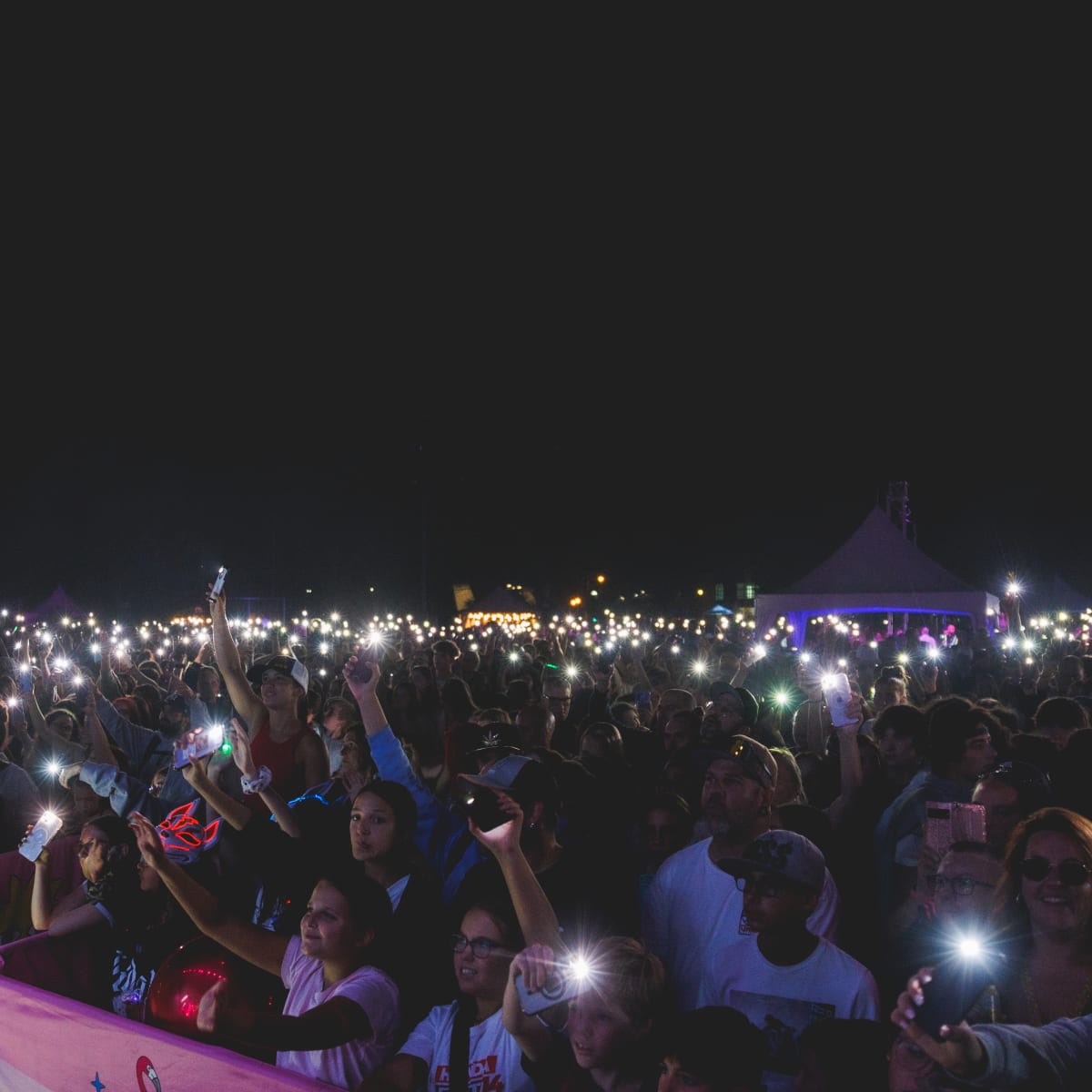 Une foule avec leur la lumière de leur téléphone allumée lors d'un spectacle au Festival POP ton été