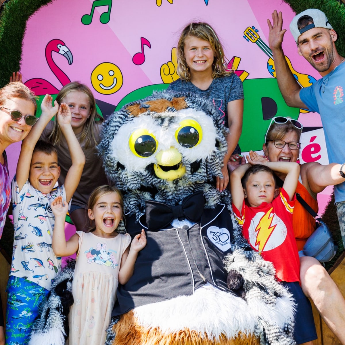 Une famille qui s'amuse avec une mascotte au Festival POP ton été