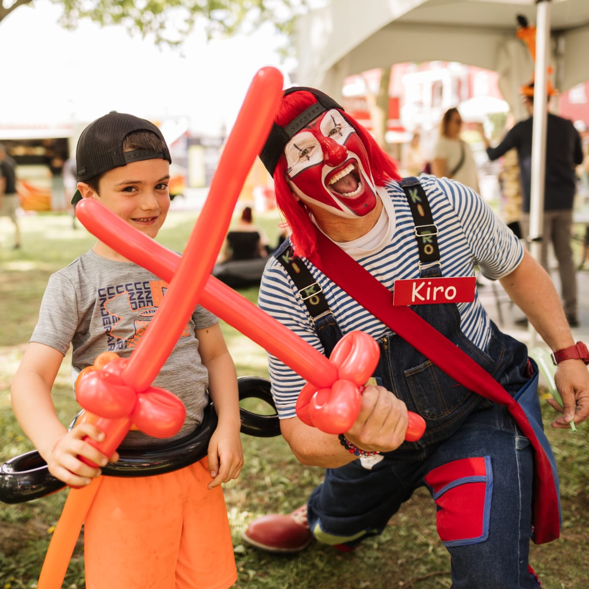 Young man and entertainer with sword-shaped balloons.