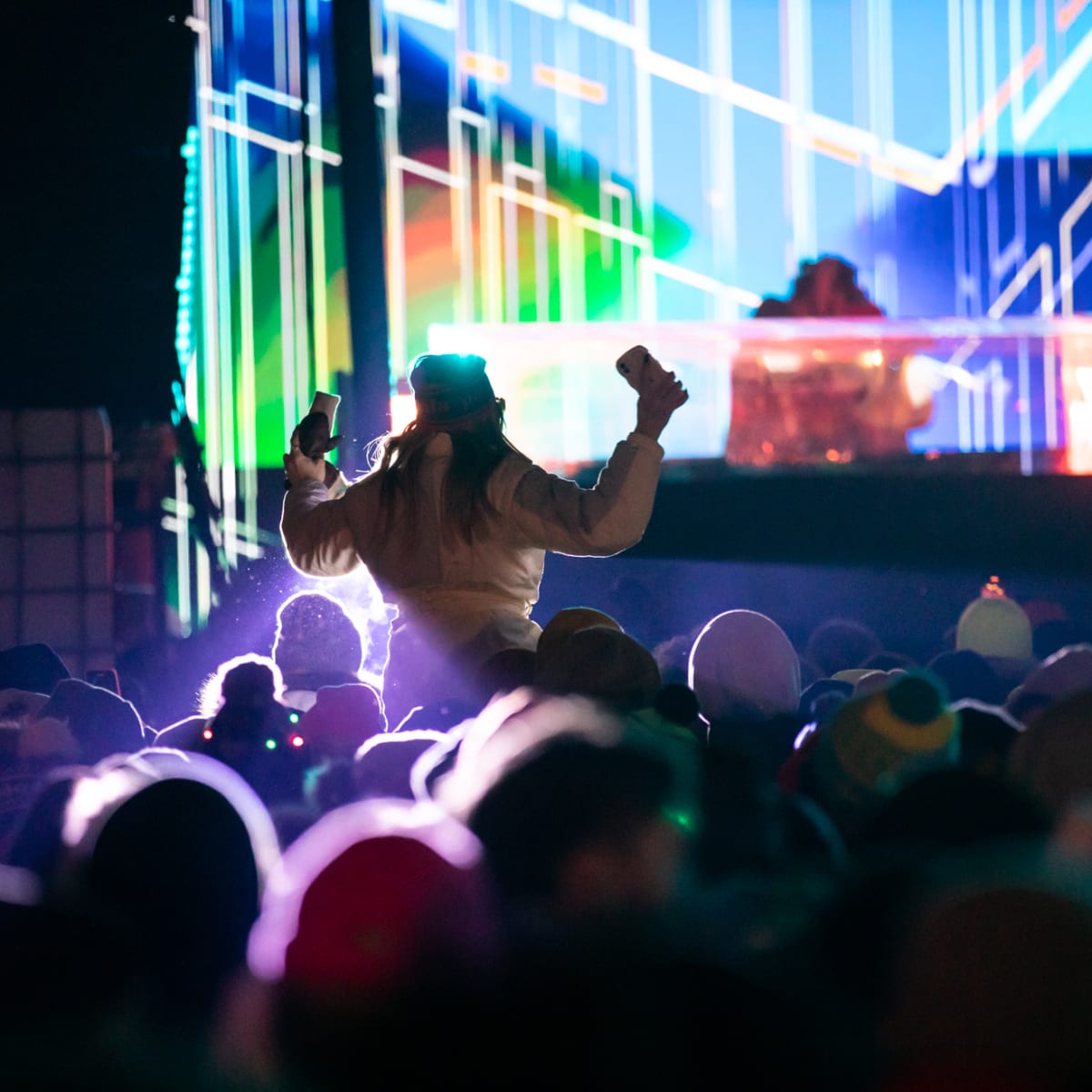 Jeune femme dansant devant de la scène d'un DJ.