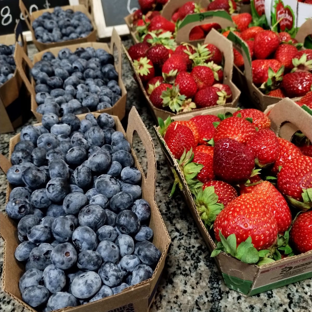Paniers de bleuets et fraises sur un comptoir.