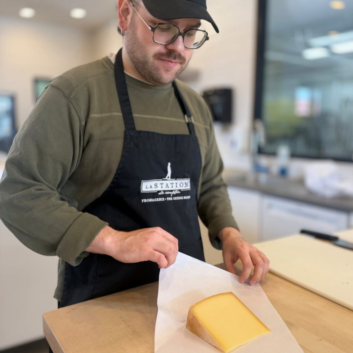 Monsieur qui emballe un fromage