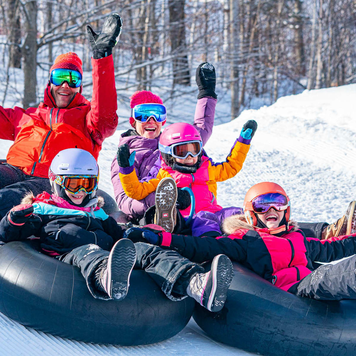 Famille aux glissades sur tube du Sommet Saint-Sauveur.