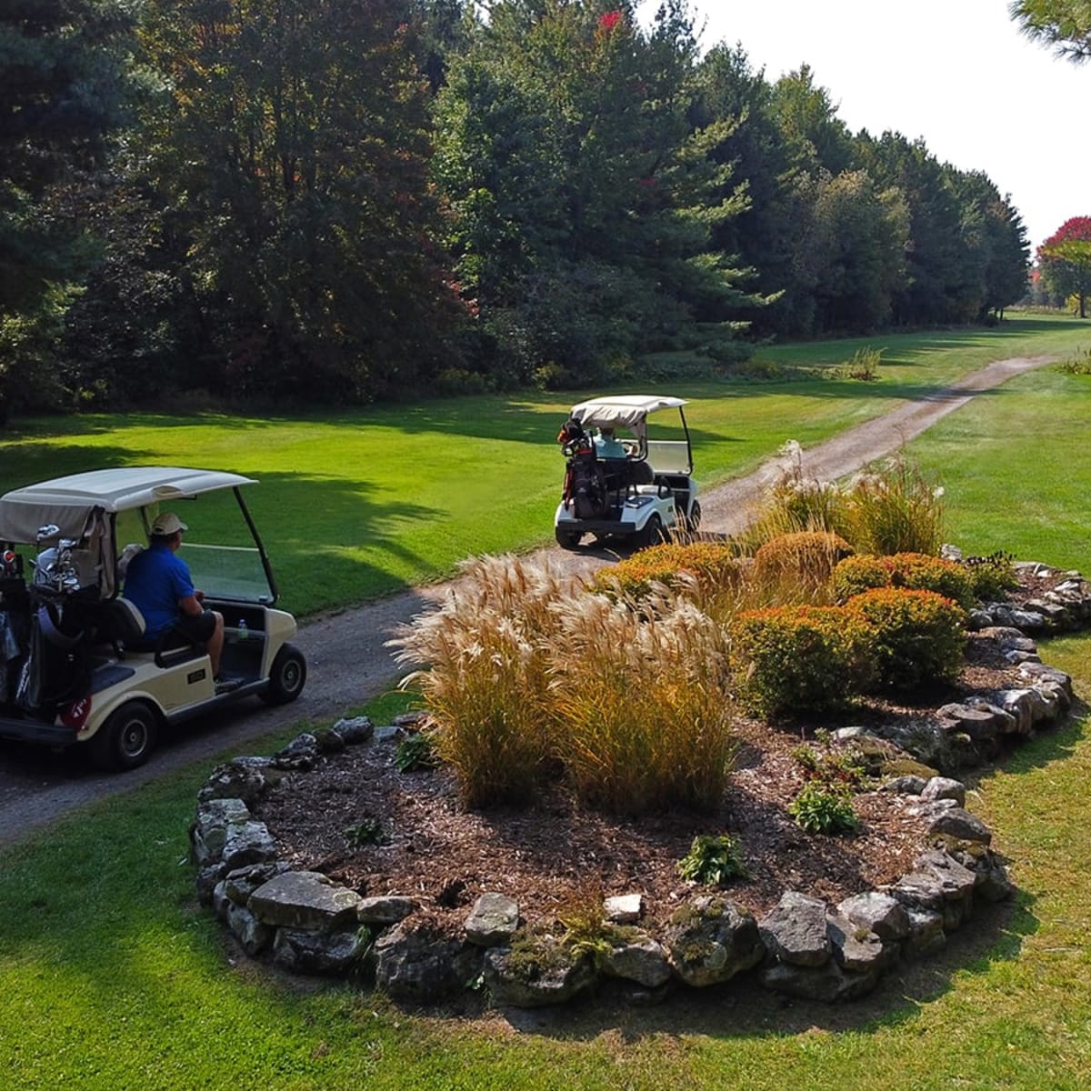 Deux voiturettes de golf sur un sentier au Club de Golf Ormstown.