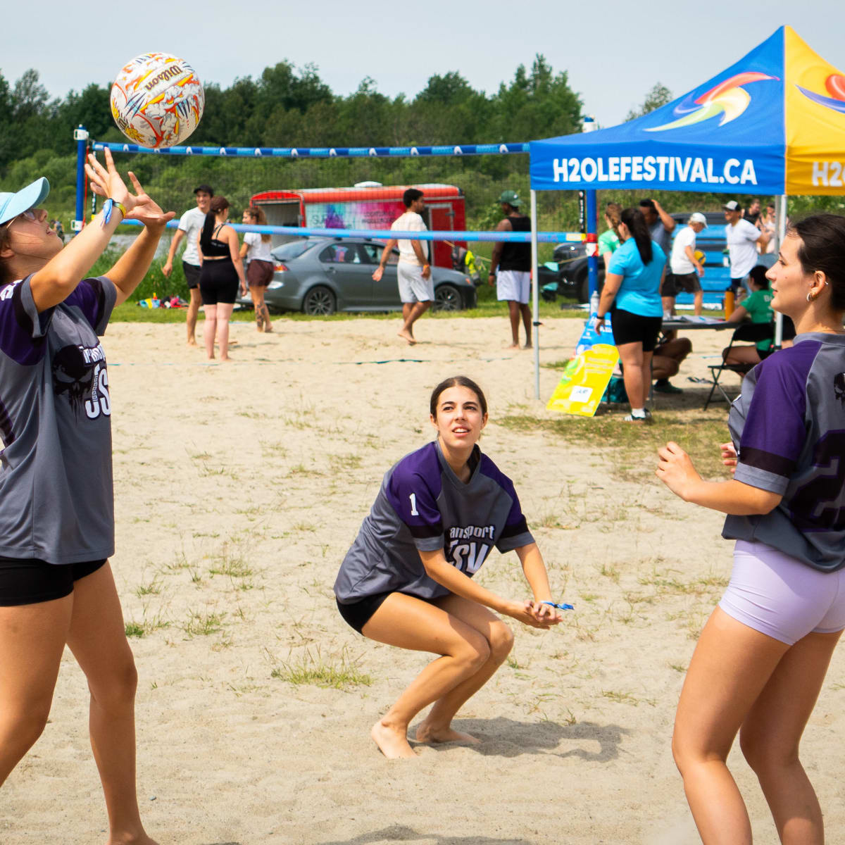 3 jeunes femmes jouant au volleyball.