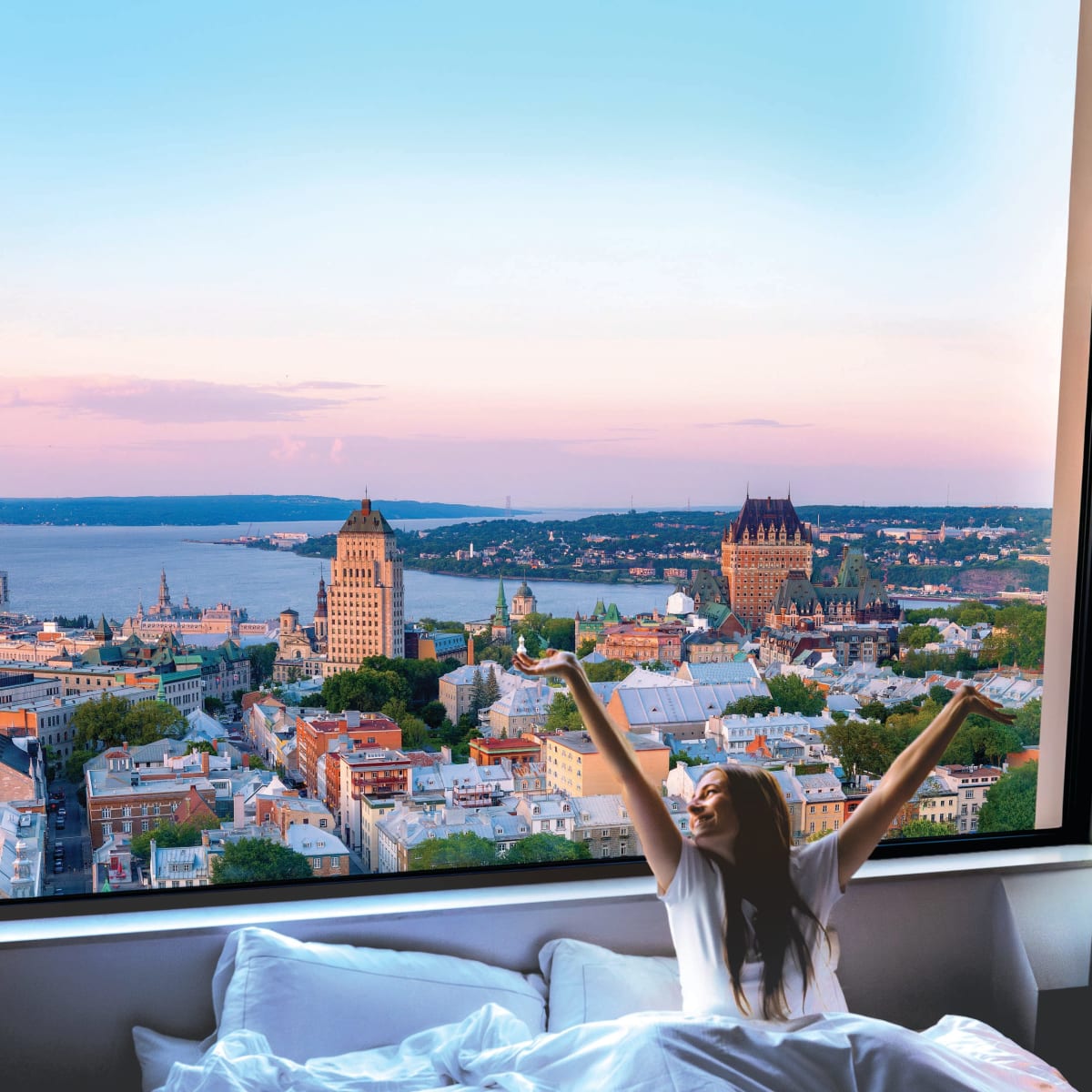 Une femme se réveillant dans un lit douillet avec une vue spectaculaire sur Québec.