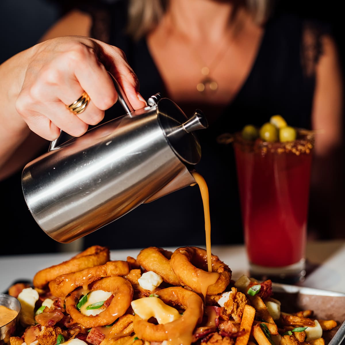Une poutine garnie de rondelles d'oignons.