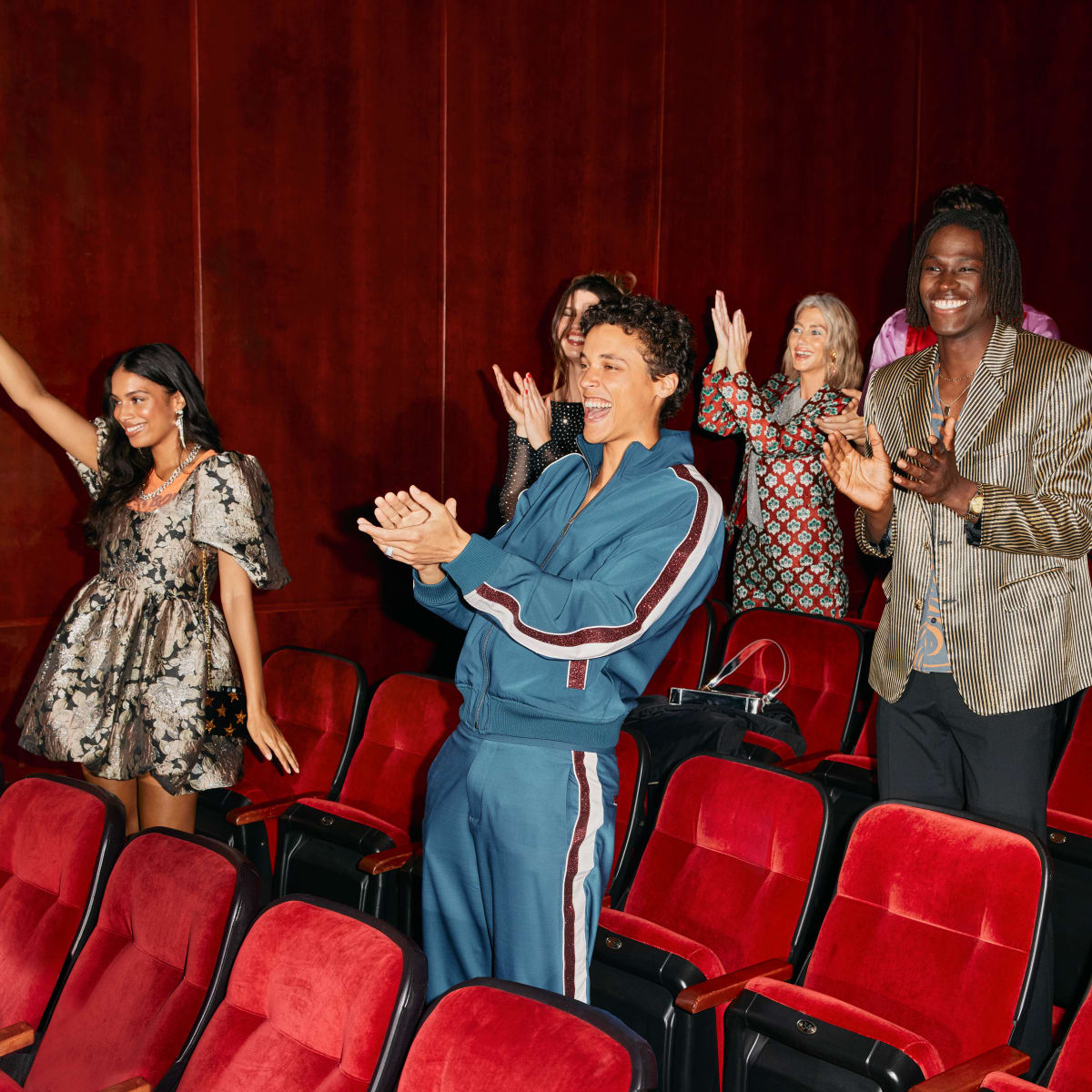Groupe de personnes applaudissant dans une salle de spectacle.