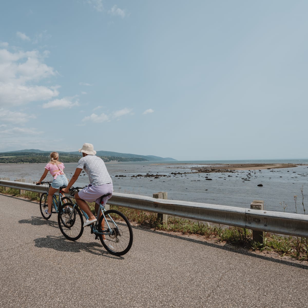 Deux personnes à vélo au bord du fleuve.