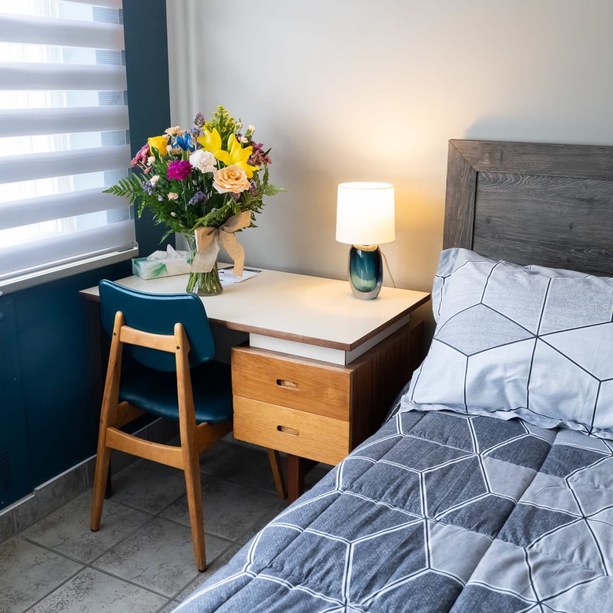 A room at the Manoir d'Youville Hotel featuring a bed and a small desk.