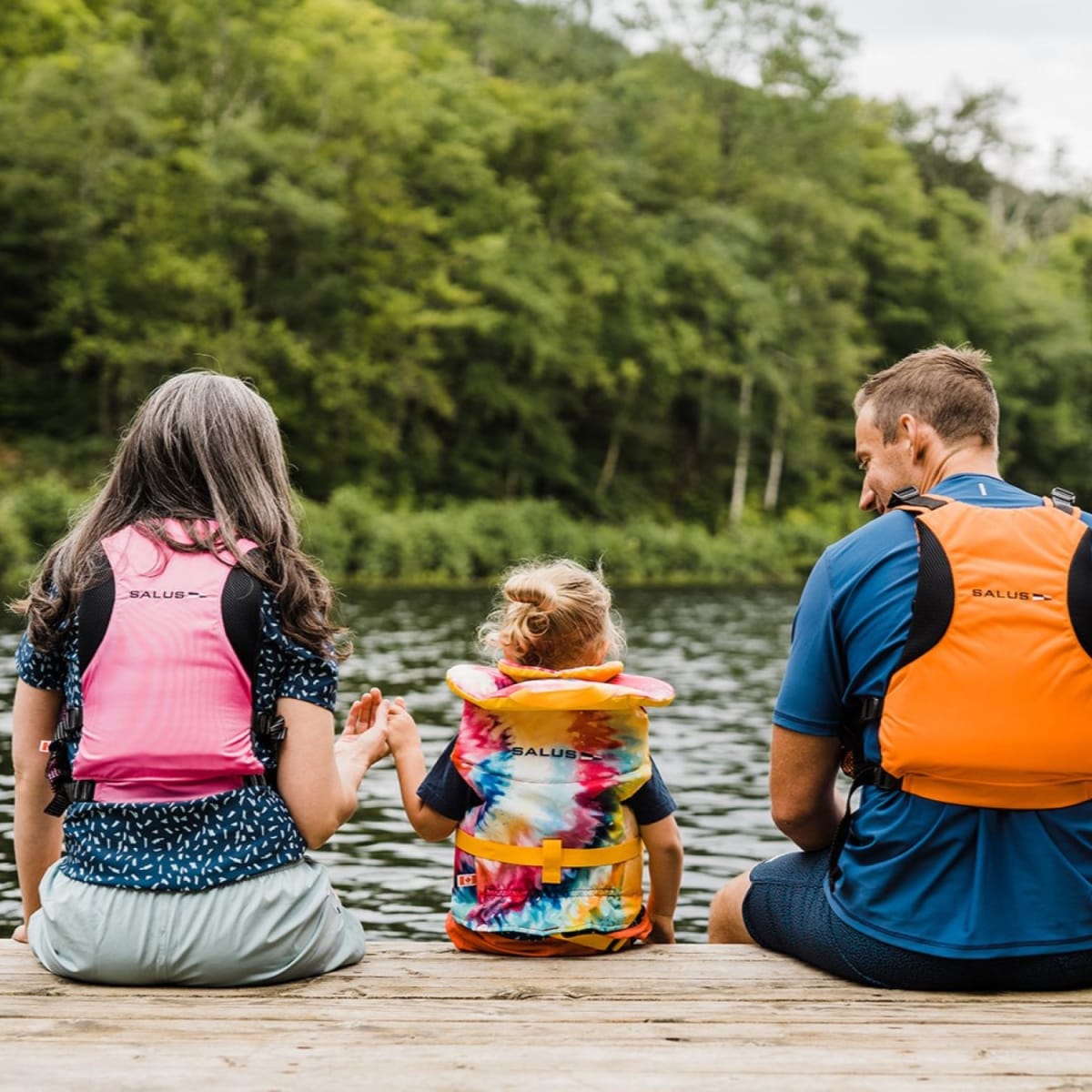 Kenauk Nature -  Two adults and a child on the edge of a quay, wearing life jackets