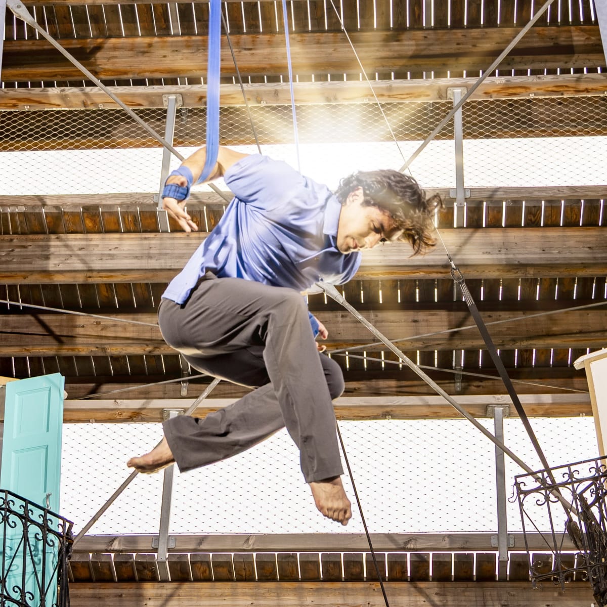 Acrobate suspendu devant des rayons de soleil. 