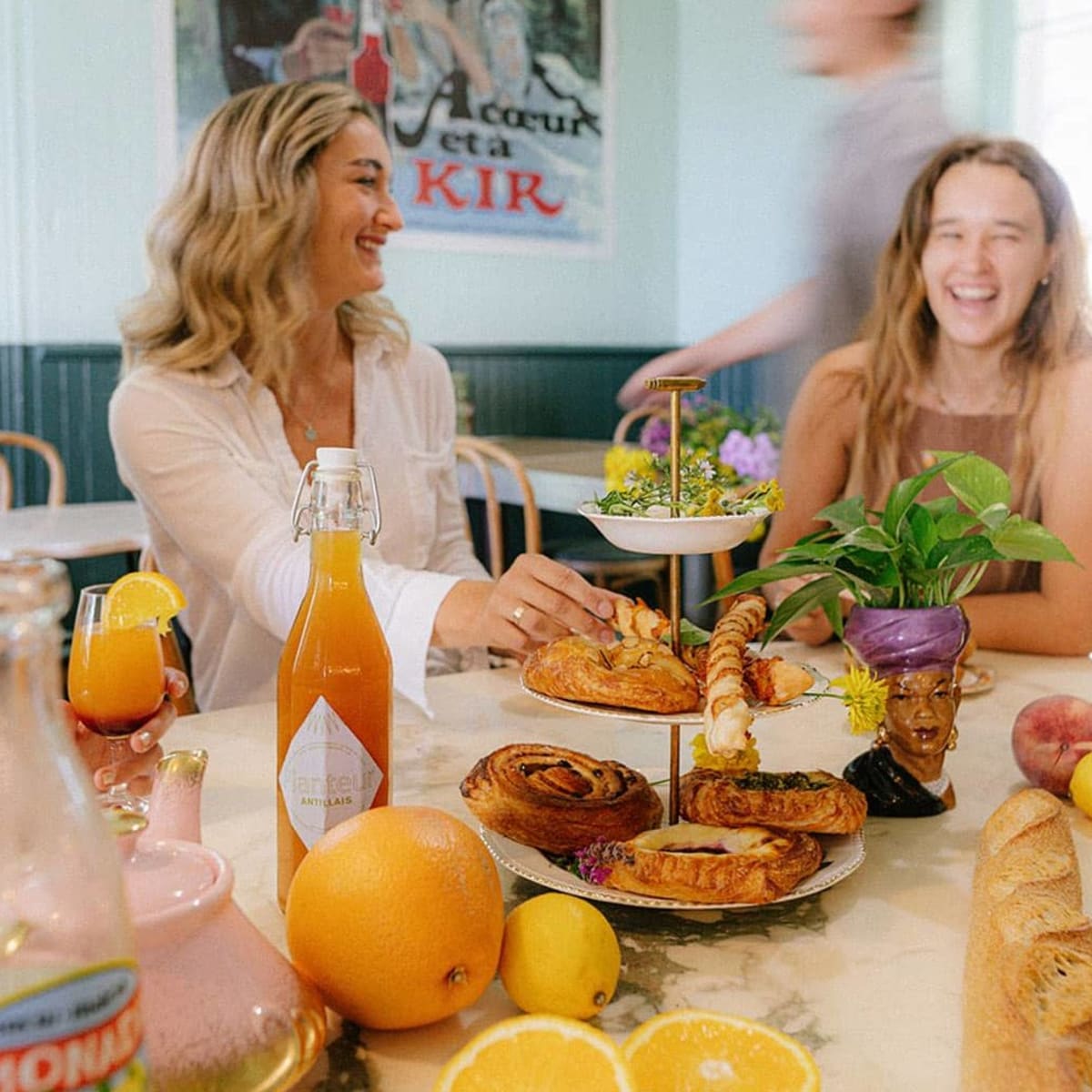 La Midinette - Women sitting at a table filled with pastries and fruit