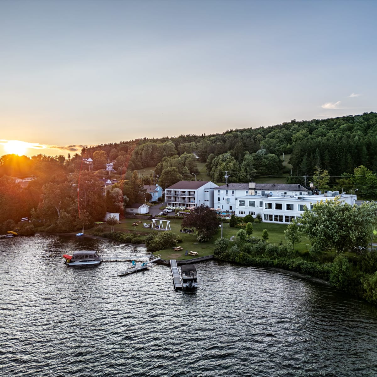 A panoramic view of the Manoir Lac-Etchemin and the lake at sunset.
