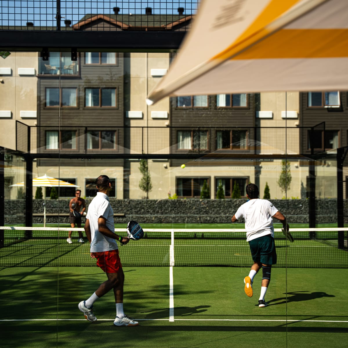 Joueurs de padel sur un terrain extérieur au Manoir Saint-Sauveur.