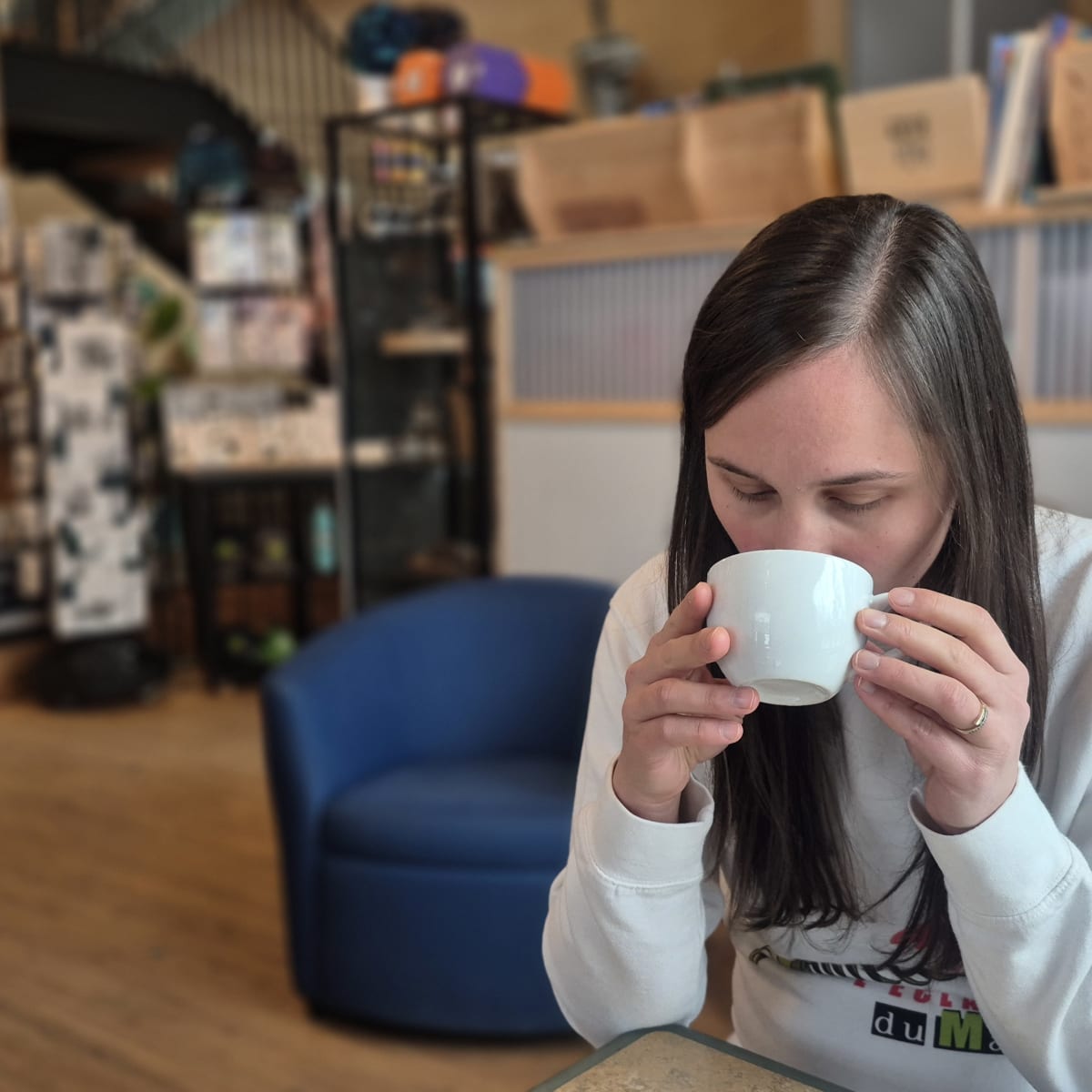 Femme qui boit un café dans une boutique.