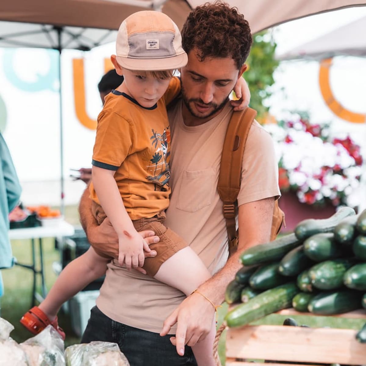 Un papa montre les légumes à son fils au marché